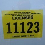 A yellow sticker reads "STATE OF NEW JERSEY DEPARTMENT OF ENVIRONMENTAL PROTECTION SOLID WASTE TRANSPORTER LICENSED 11123" with "EXPIRES JUNE 30, 2013"—essential for licensed junk removal in Passaic County NJ.