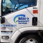 A white truck with "Mike's Cleanout Services," a phone number, and "Clifton, NJ" on the door—offering junk removal in Clifton NJ. An orange permit sticker and the name "Mike" appear above the window.